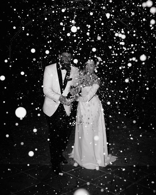 A bridal couple spraying champagne into the air.